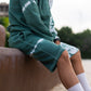 Men's tie dye green fleece shorts, knee length with drawstring.